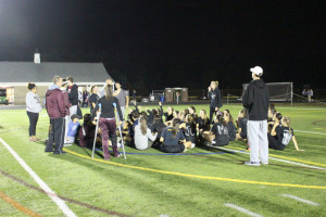 Seniors sit on the field after their game to protest the way their game ended 