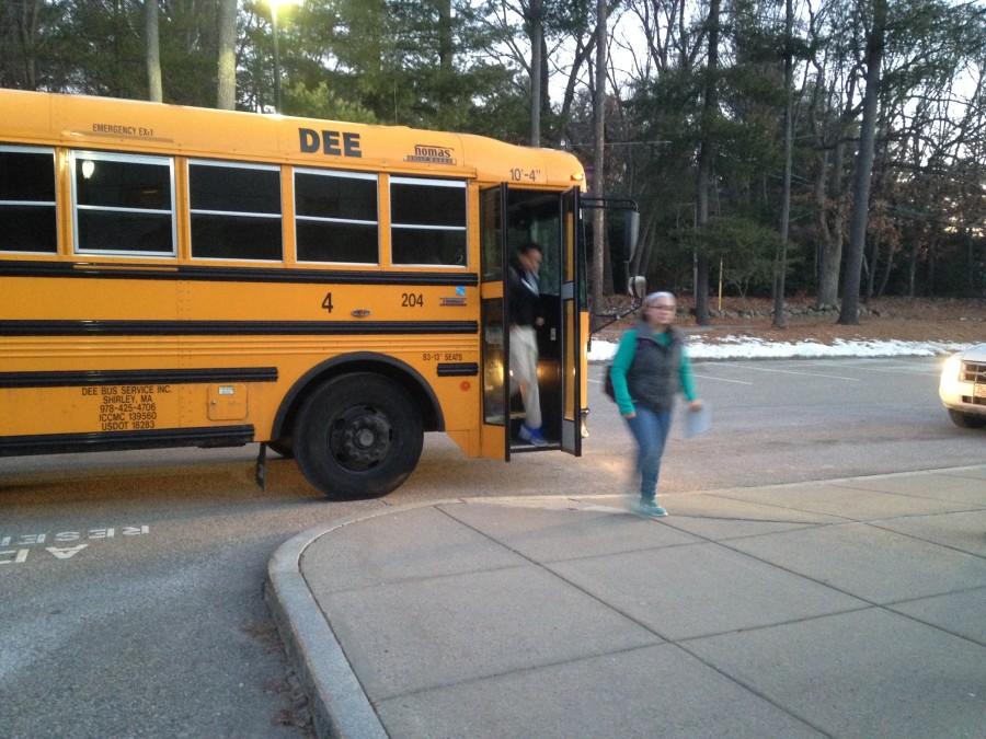 Students depart from a bus in the morning.