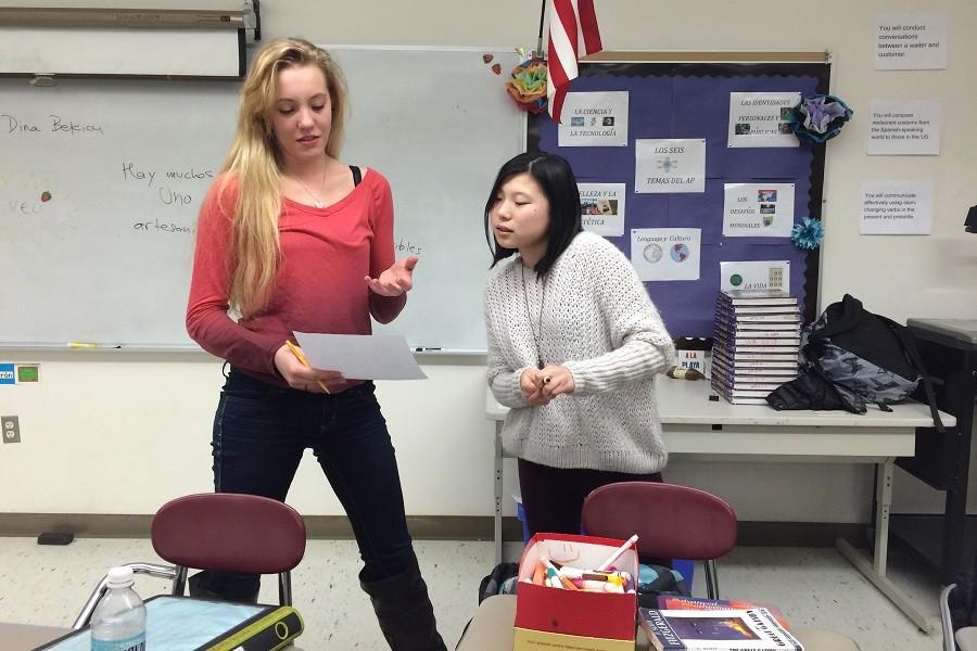 Juniors Lily Shan and Kelly Ann Cooper discuss poster ideas.