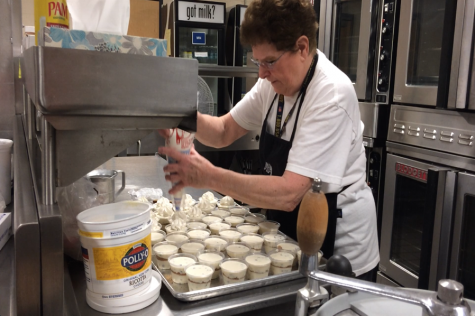 Denise placing whipped cream on the cannoli cups