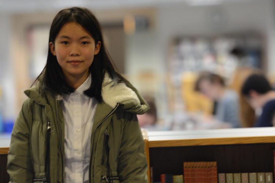 New exchange student Cici poses hello for camera in the library. 