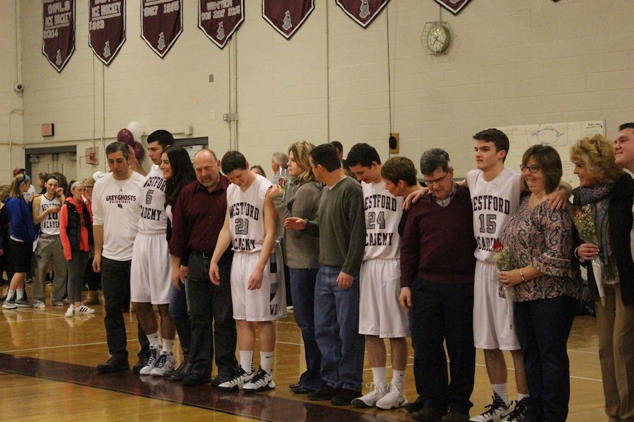 Senior basketball players lining up with their parents 

