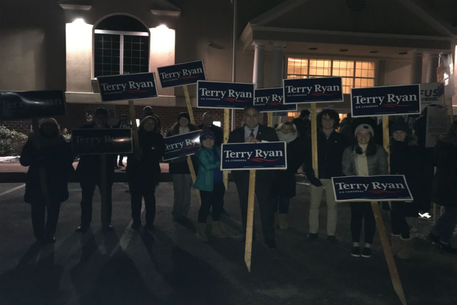 Terry Ryan (Front) with supporters holding signs before the forum. 