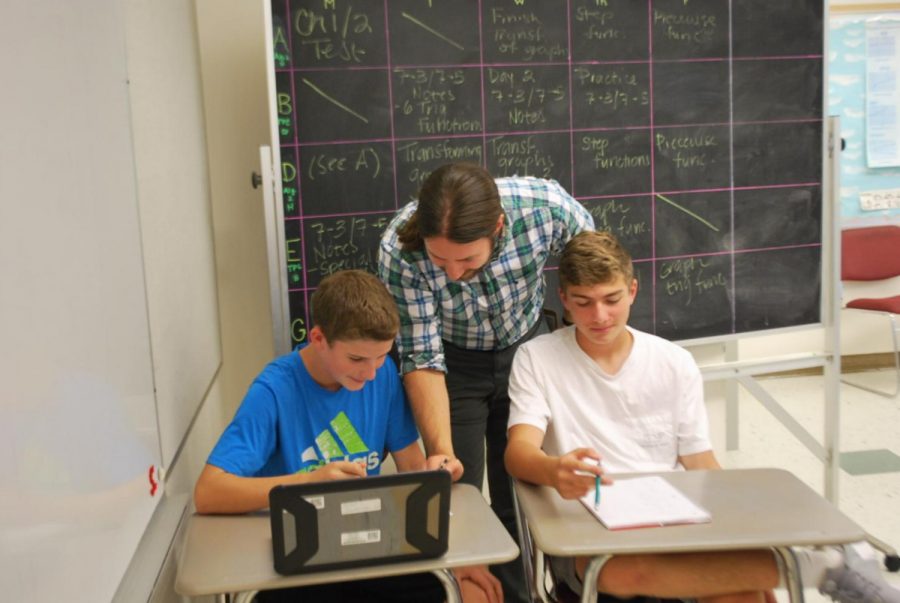 Samuel Hummer helps two students in his F Block algebra class.