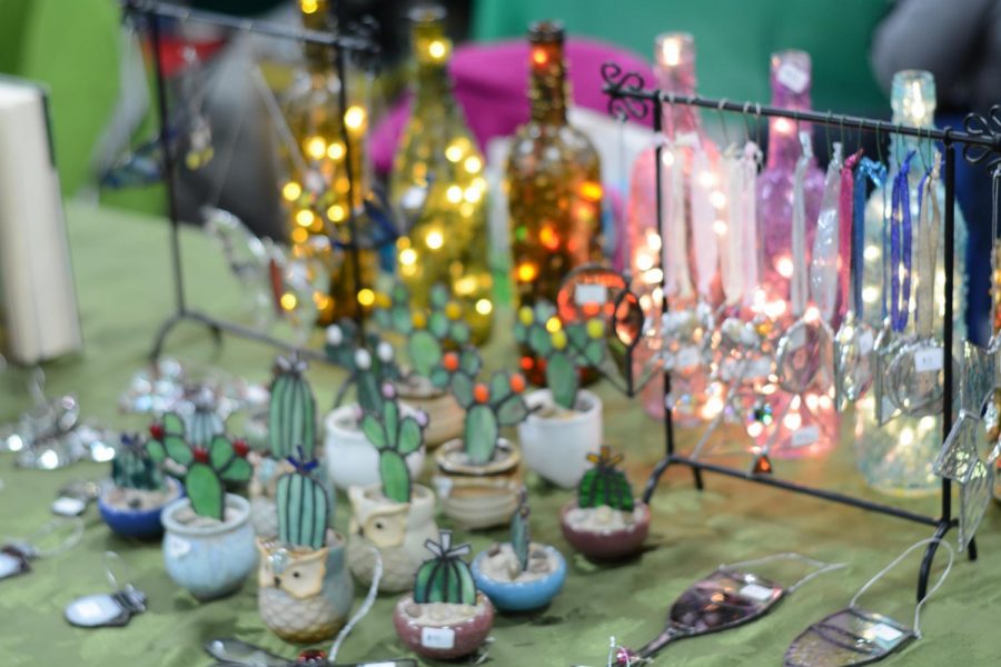 A vendor sets up a display of glass and lights.