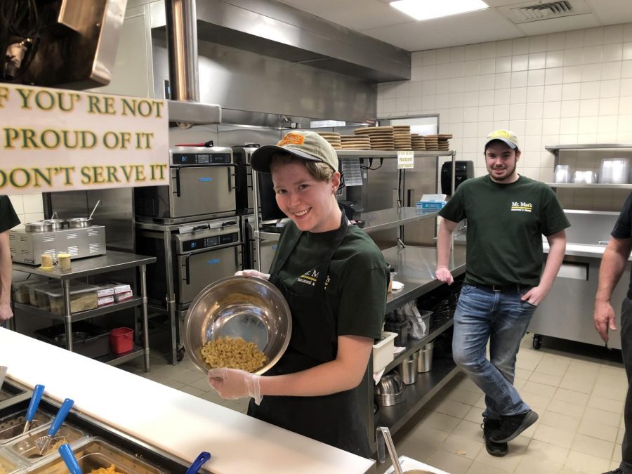 Mr. Mac employee holds up a bowl of pasta as she makes an order. 