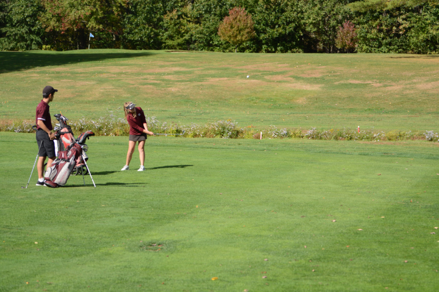 Junior Ryan Smith watches while captain Morgan Smith hits an approach shot onto the first green. 