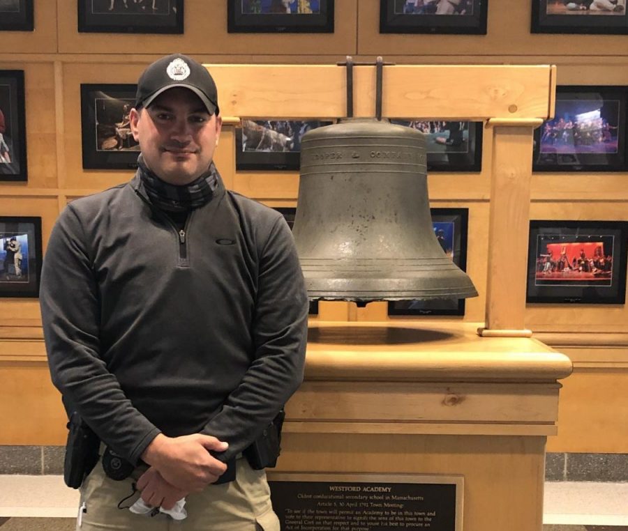 Detective Pavao stands in front of the bell in the bell lobby.