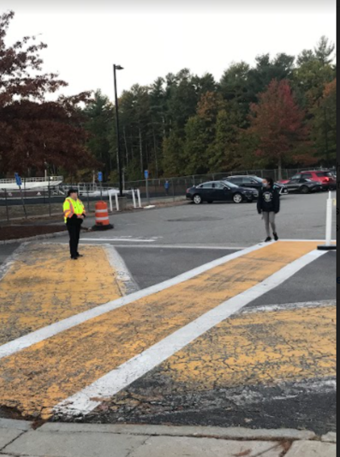 Crossing guard Patty Green directs traffic and helps students cross the road in the morning