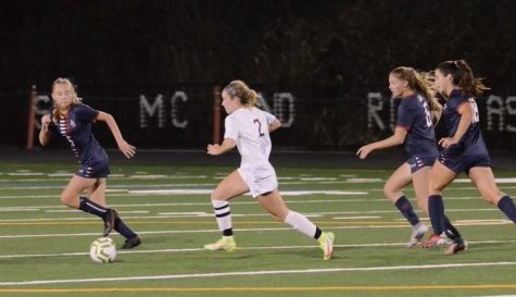 Senior Isabel Doherty chases after a soccer ball during a game.