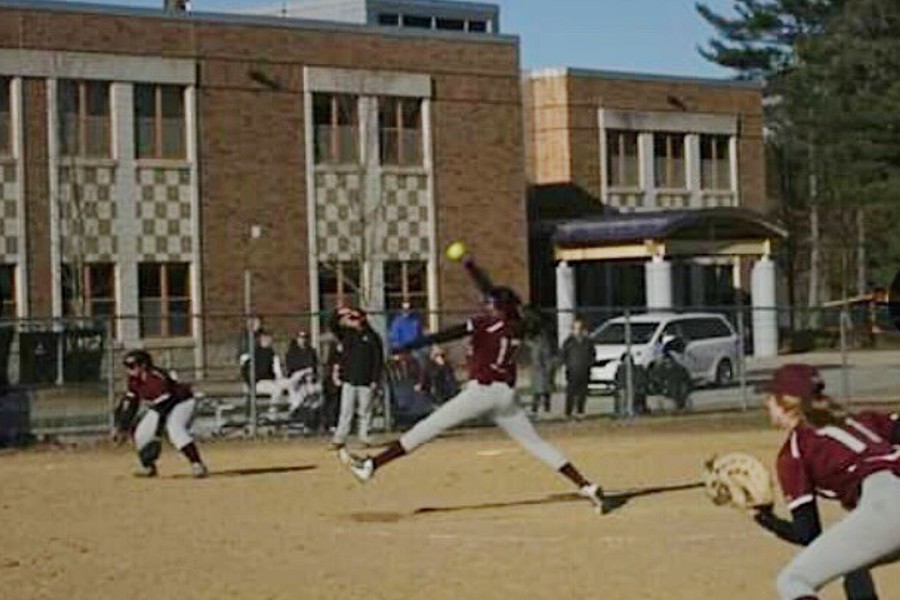 Kannan (middle) pitches a bright green softball.