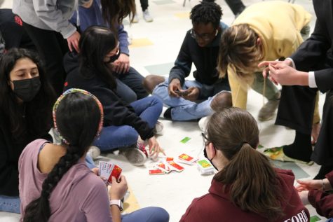 An Apples to Apples game sparks discussion amongst several of its players.