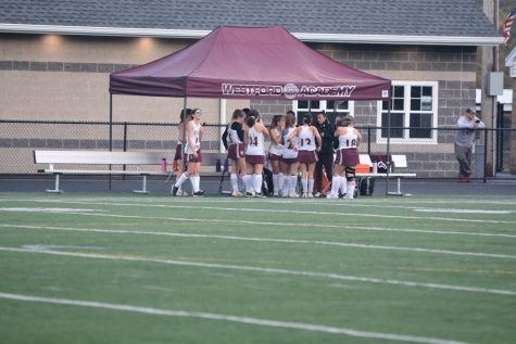 Before the start of the first quarter, WA huddles with Coach Sara Piper for a pep talk.