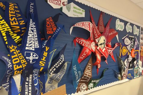 College flags and banners hang on the wall of the guidance department.