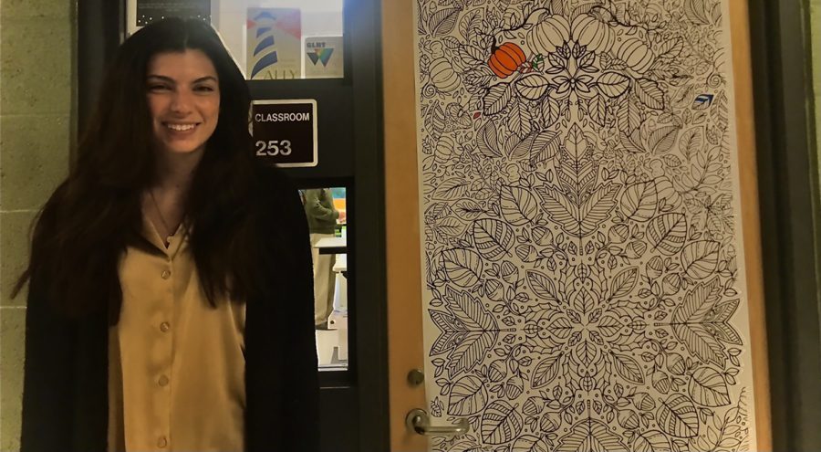 Cournoyer stands next to her classroom door, complete with the new coloring sheet, in room 253.