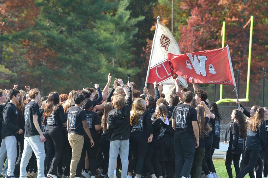 Seniors celebrate by jumping together around their school and class flags. 