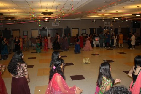 Guests form a circle and begin to dance Garba, a type of traditional Indian dance originating from the state of Gujarat.
