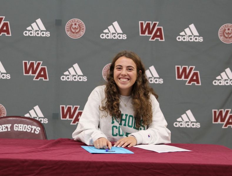 Felicani signs her commitment to Nichols College. 
