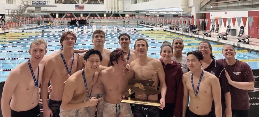 The+boys+swim+team+poses+for+a+picture+with+their+coaches+after+the+state+championships.+