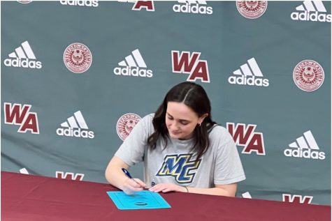 Burns signing her commitment to Merrimack College.