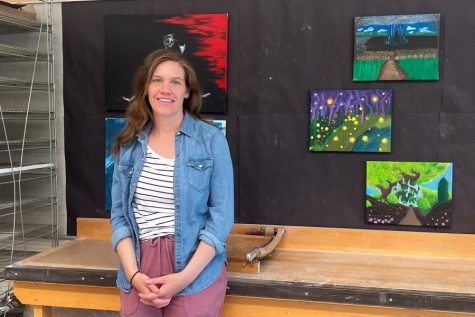 Lampert smiles in front of her students artwork.