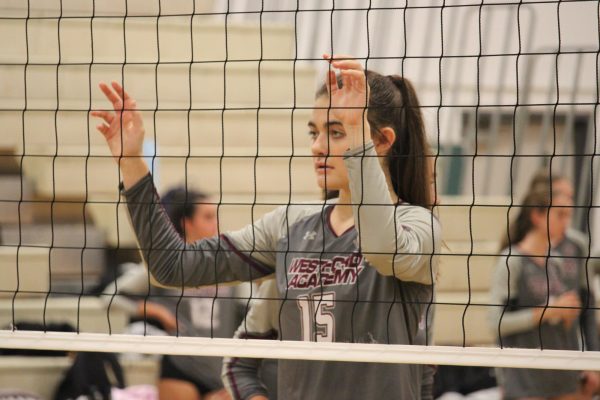 Senior Jocelyn Vogel blocking the view of the other team while looking through the net.