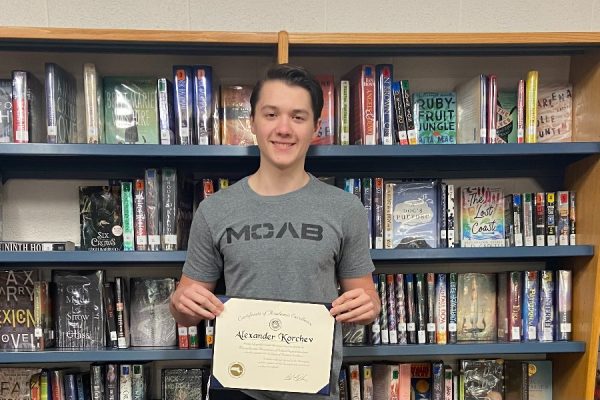 Korchev poses with his M.A.S.S. Award in the library.
