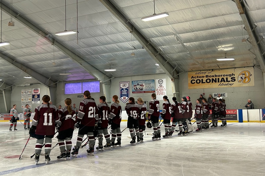 WA Girls Hockey stands for the national anthem before their game begins.