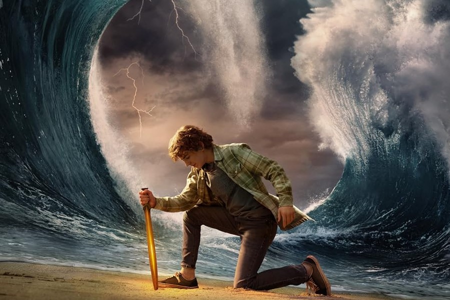 Percy Jackson, played by Walker Scobell, poses in front of a wave.