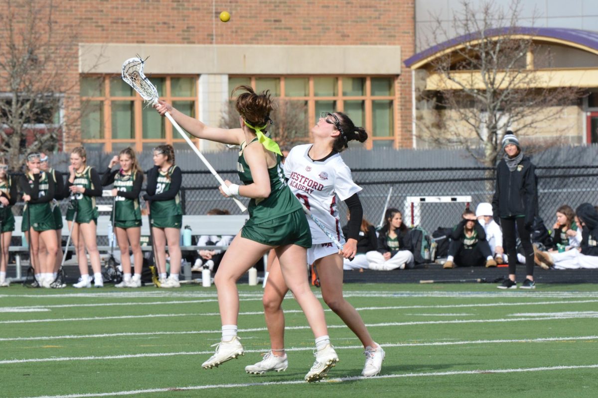 Freshman Kiley Carmichael battles with a Nashoba Regional player for the ball after a face-off during the first quarter.

