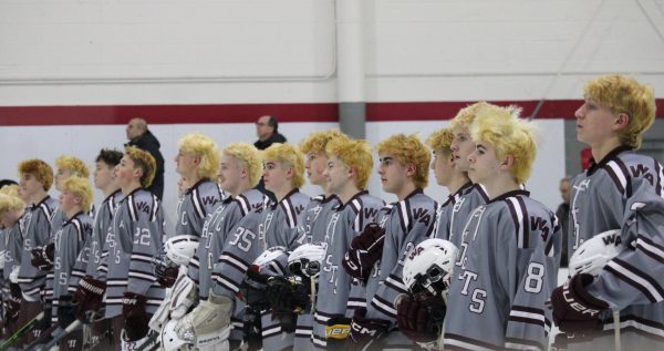 The team lining up for the National anthem with all bleached hair being visible. 