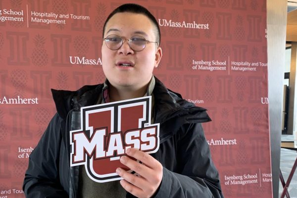 Quan holds a sign for UMass Amherst, where he will be going to college.