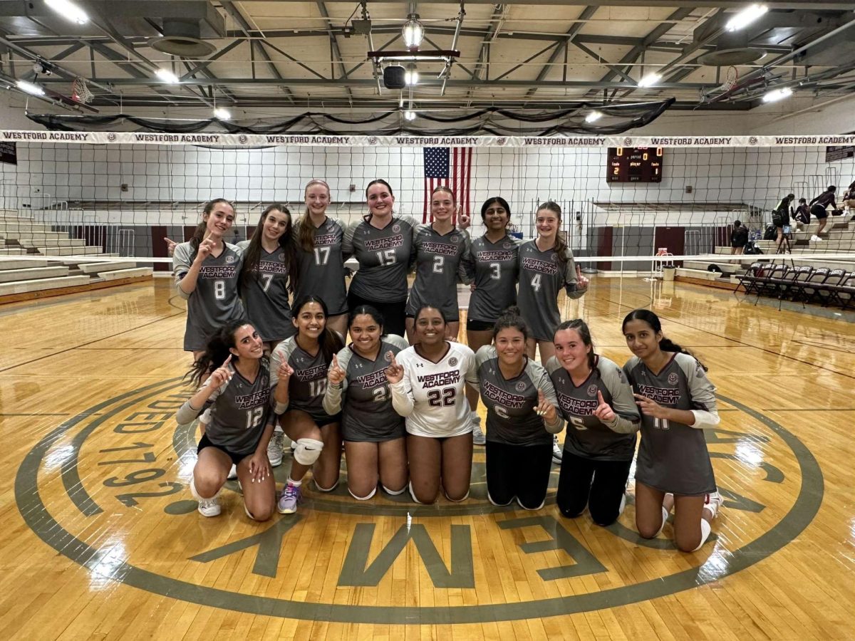 The Girls' Volleyball team poses for a picture after a win

