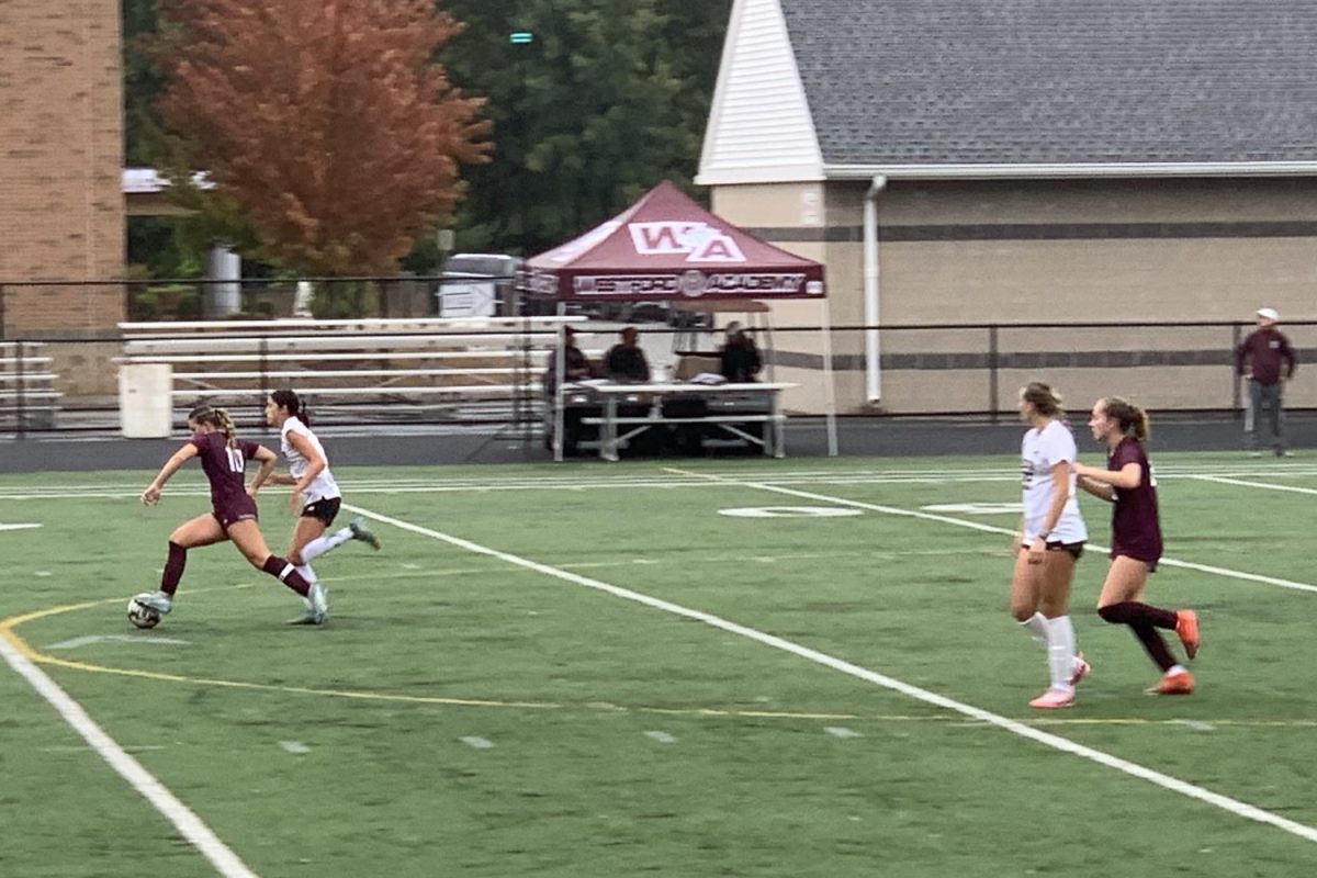 Senior captain Ella Diruggiero rushes down the field with the ball.