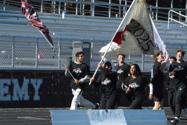 The WA seniors race onto the field just before the rally begins, waving their class flag. 