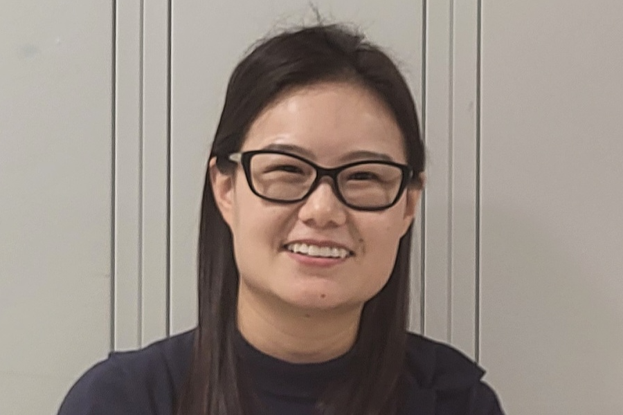 Ying Ma standing outside her classroom.