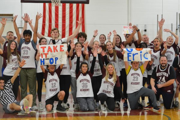 Enthusiastically holding up their hands and posters, the Unified Basketball team celebrates both their victory and a successful event. 