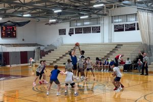 Senior forward Vishal Rampur and a Tewksbury player leap for the ball during the tossup at the beginning of the scrimmage. 