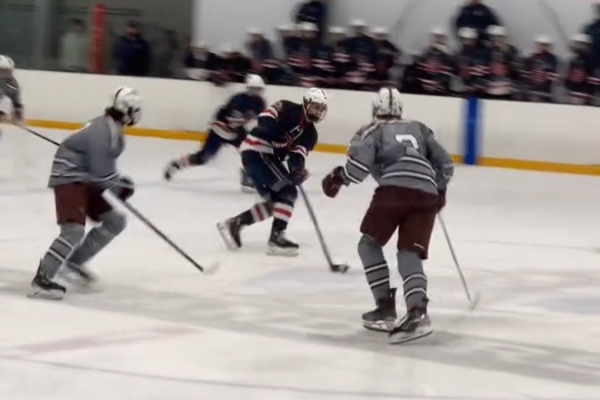 The Ghosts converge on a Central Catholic player in an attempt to steal the puck.