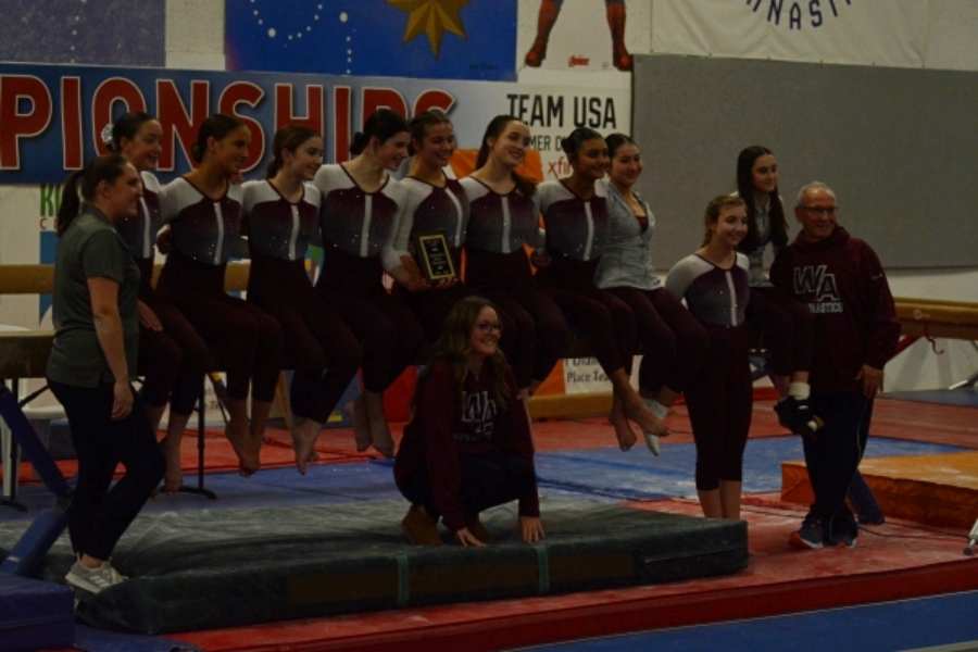 WA Gymnastics lines the bar after the DCL award ceremony for a group photo.