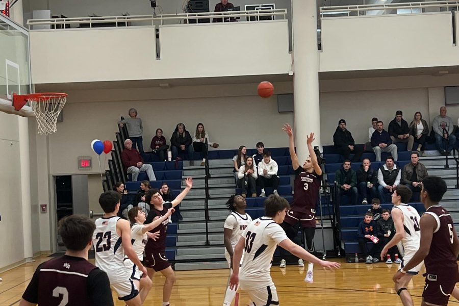 Senior captain Nate Pitts hits a three while Lincoln-Sudbury players prepare for the rebound.