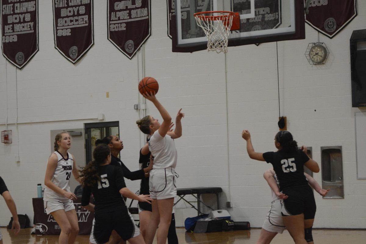 Junior Olivia Pillsbury aims to shoot a basket, assisted by juniors Brooke Nielsen and Maddie Smith, as CRLS closes in to stop her.