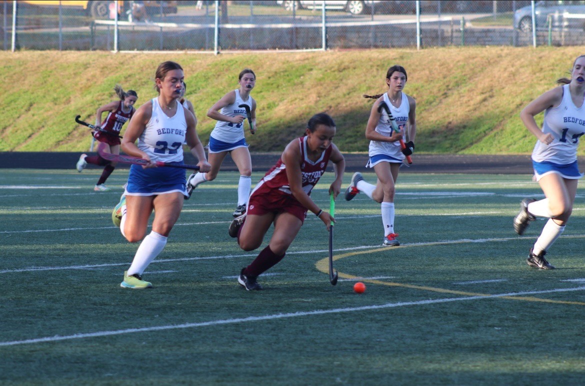 Lia Arevalo chases the ball as other players try to surround her