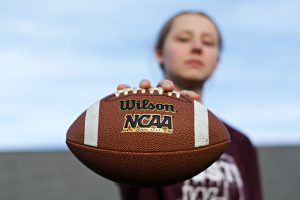 Nielsen holds out her football at the team's first-ever practice.