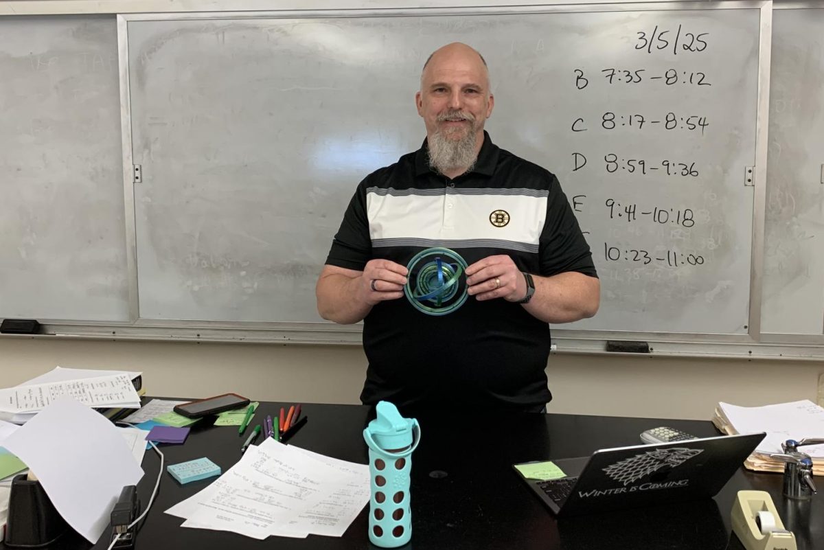 Knittel holds a gift from former student Jack Whitman who was able to achieve a perfect score on the AP Chemistry exam in large part due to Knittel's lessons.