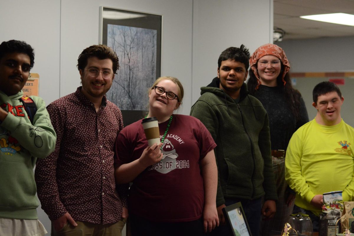 Members of ROUTES stand side by side in front of the coffee shop area. 