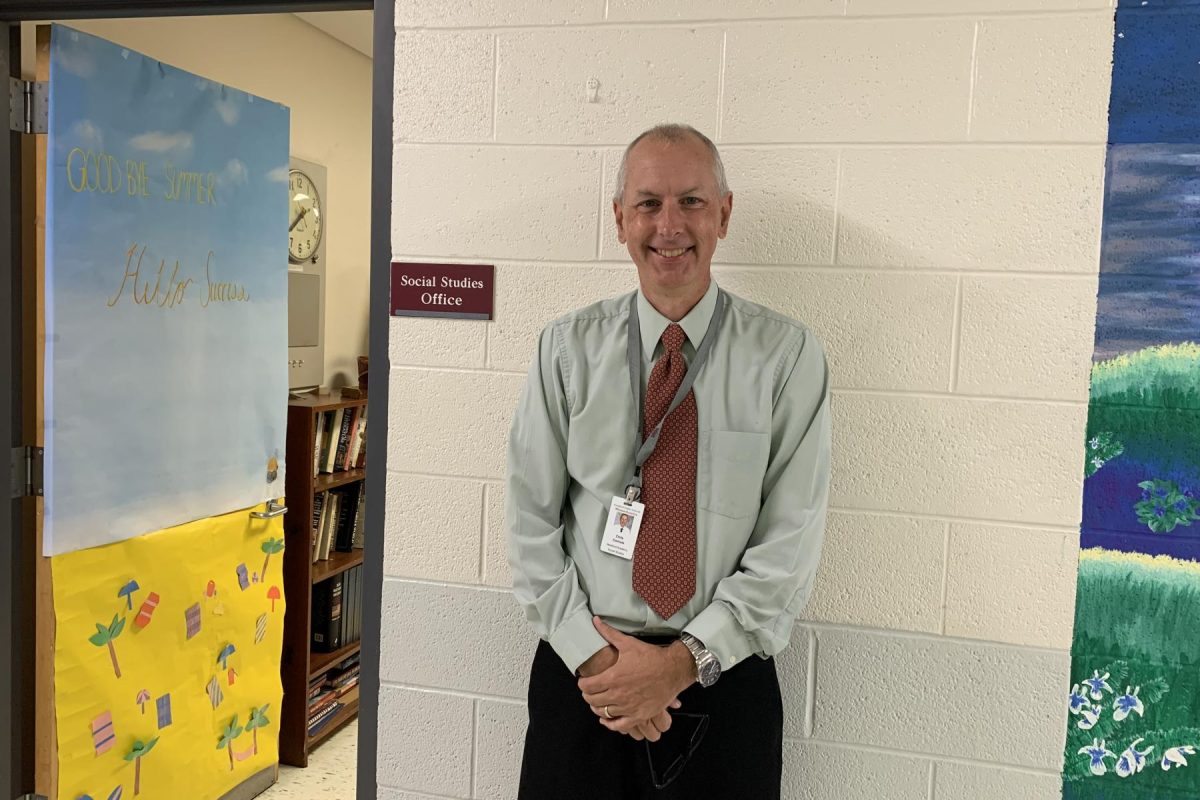 Connole stands at the entrance to the Social Studies Office where teachers often grade, discuss, and prepare class materials.