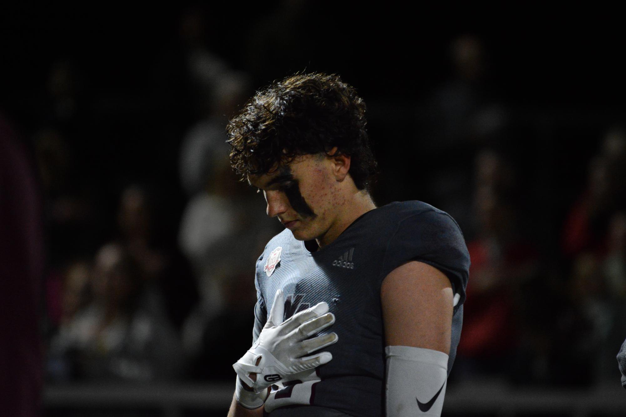 Senior captain Teddy Hirbour stands in silence during the national anthem.