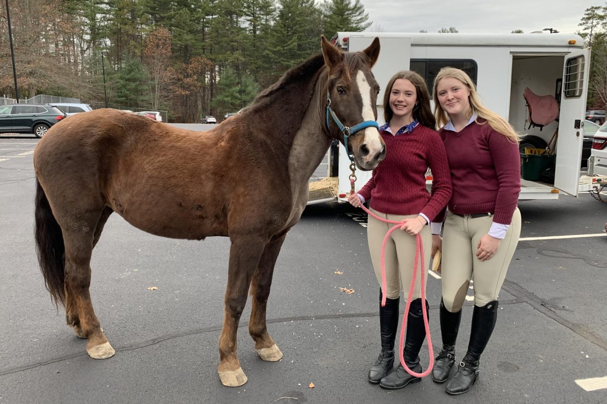 Equestrian Team senior captains Lizzie Tripp (left) and Catherine Newark (right) stand next to Tripp's horse, Genna.