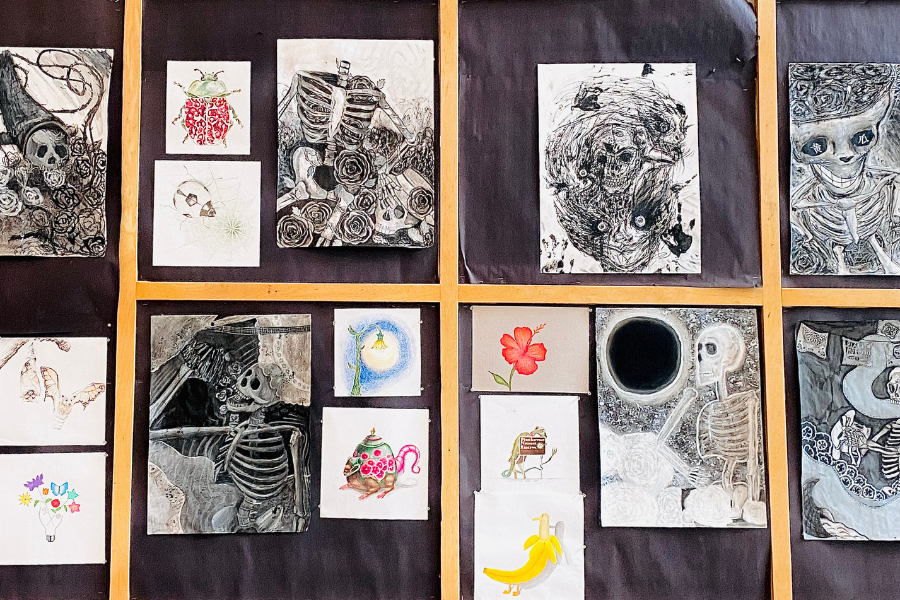 Artwork made by WA students hangs on a bulletin board in the Flag Lobby.
